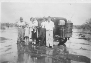 L to R Felix L Dot, Mrs Reason and children and old Jack from mine garage. Taken during the flood. Ote gas producers on the back of car. Circa 1930s.