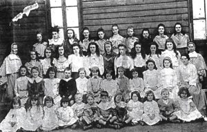 Students and Staff of the Girls High School standing alongside the Old Church of St John the Baptist, Kalgoorlie - 1905