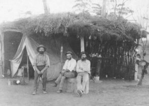 Douglas William GRAY and friends outside their prospecting camp 1898-99,in a tent covered in brush and canvas water bag billy and Taken by Rembrant Studio : Photo donated by daughter Jessie Gray 1989.