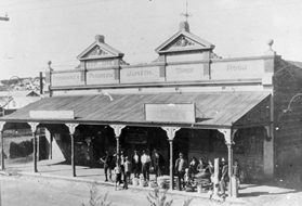Some of J.Fitzpatrick & Co staff and their sons pose in front of the showroom building completed in 1918 with several smaller items made in the plumbing firm's workshop at the rear of the large Chapman Road block, originally 171 Eleanor Street, Geraldton.