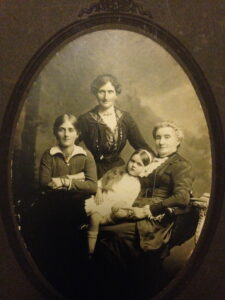 Four Generations - Standing Lilis Townsend nee McPhail, seated L-R her daughter, Jessie Grace McKenna nee Townsend, Lilis McPhail nee Nevin holding Joan Mary McKenna, Jessie daughter.