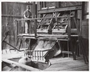 Miner moving ore moving from bin to cracker at Chaffers Mine, Kalgoorlie, 1948 - Photo SLWA