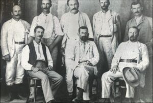 William Cock is seated on the far left. Others are unknow, The stout man in white (middle standing) may be G W Hall. - Photo
